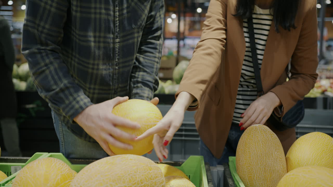 Couple Shopping for Cantaloupe at the Grocery Store