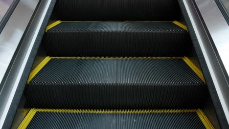 escalator is moving up with light and shadow in building.  medium shot.