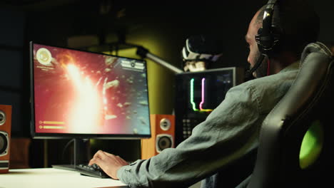 man using headphones to enjoy online spaceship videogame with friends