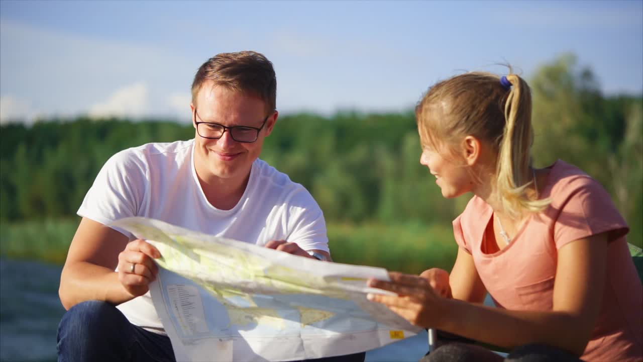 Couple Exploring a Map by a Lake