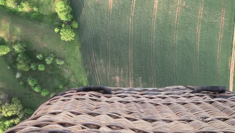 Mit-Einem-Heißluftballon-über-Felder-Und-Bäume-Fliegen,-Blick-Nach-Unten-Mit-Einem-Korb,-Tolle-Filmische-Aufnahme-Mit-Gefühl-Für-Den-Augenblick-In-Der-Luft