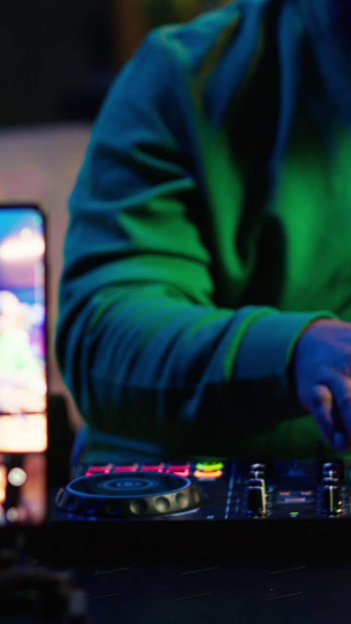 DJ afroamericano che mixa musica con controller di notte
