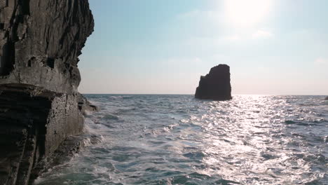 waves crashing against coastal rocks with sea stacks