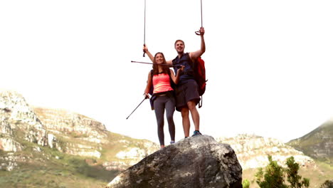 una pareja alcanzando la cima de su caminata.