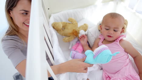 mujer jugando con muñecas con su bebé