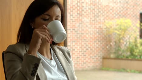 Mujer-De-Negocios-Tomando-Cafe