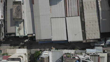 top down drone shot flying low over rooftops in urban residential area of major city in south east asia