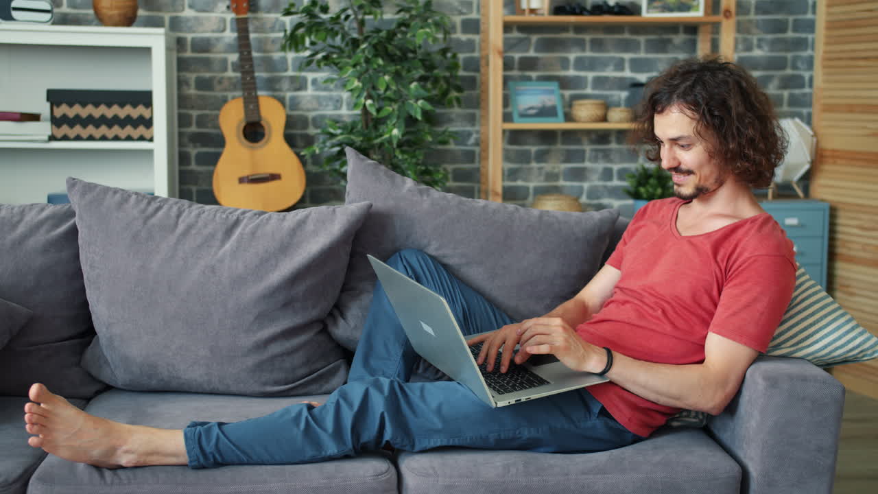 Man relaxing on a couch using a laptop