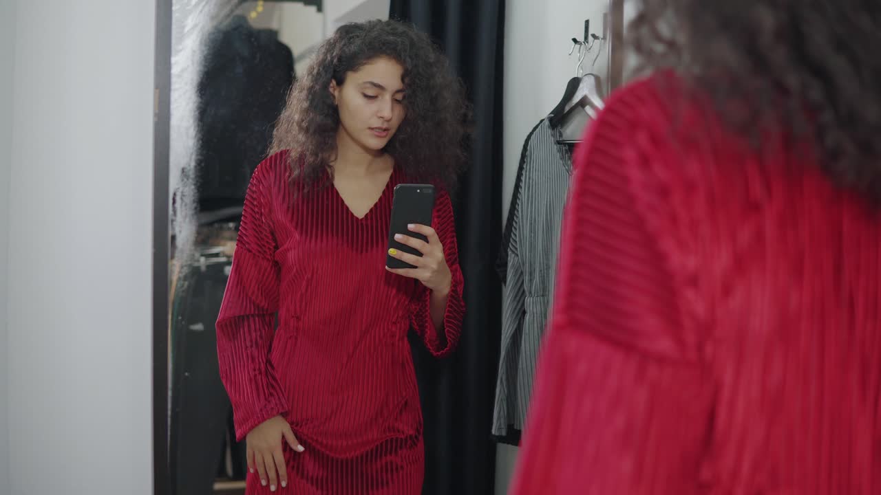 mujer intentando un vestido rojo en un camerino
