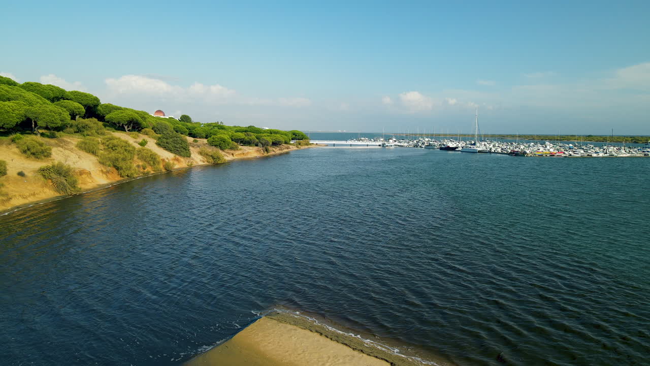 puerto el rompido velero y club náutico con muchas embarcaciones amarradas en el muelle del río piedras, retroceso aéreo con la naturaleza de las dunas de andalucía