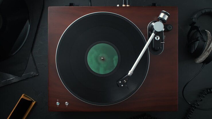 Wooden Record Player with the Tonearm Lowered onto a Vinyl Spinning in Slow Motion - Top View of the Audiophile's Table