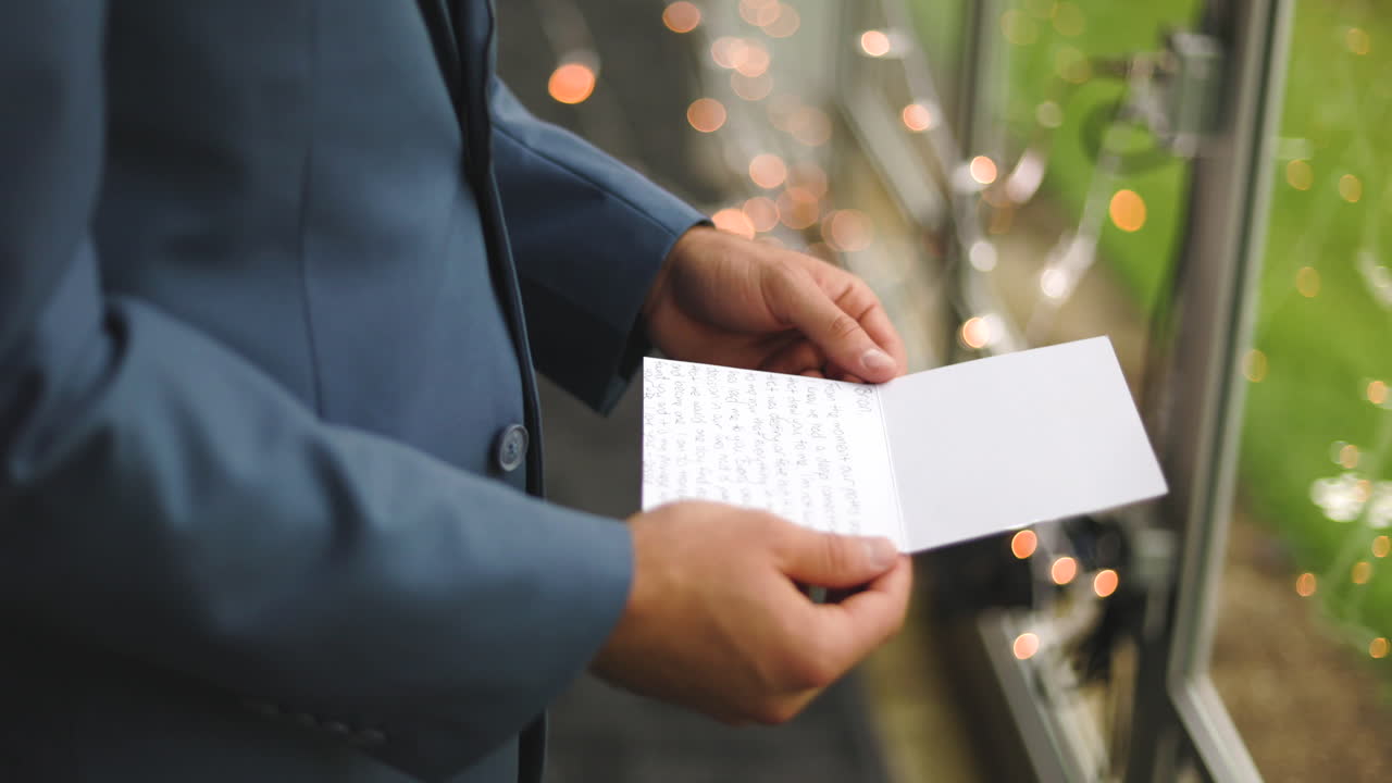 Groom reading a hand written note on his wedding day
