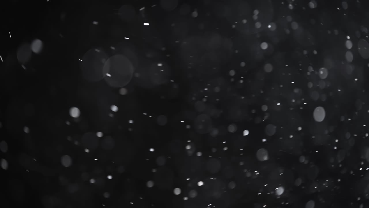 Floating abstract particle bokeh on dark background