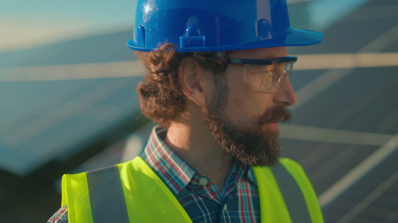 Man in safety gear near solar panels