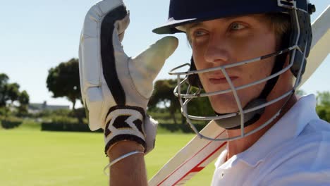 bateador con casco y bate en el campo de cricket