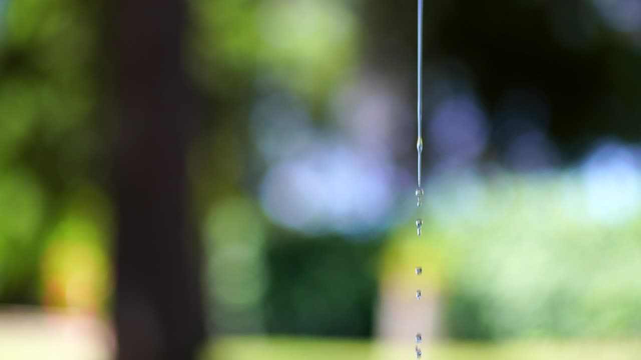 una corriente de agua fina que fluye lentamente sobre el fondo de una naturaleza increíble. agua refrescante y refrescante en un día soleado de verano. movimiento de agua abstracto en una foto macro