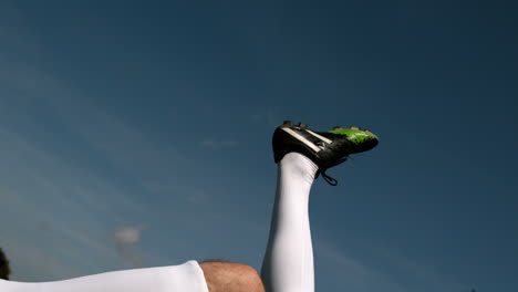 Jugador-De-Fútbol-Pateando-La-Pelota-Bajo-Un-Cielo-Azul