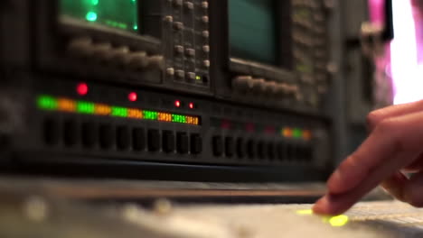 person adjusting controls on a vintage electronic instrument