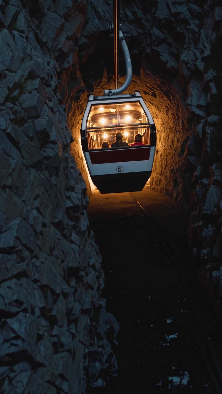 Funivia in movimento attraverso un tunnel montano buio