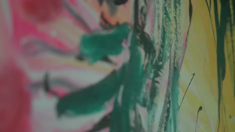 close-up shot of a colorful abstract painting with dynamic brushstrokes in pink, green, and yellow hues