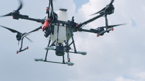 drone pulverizador vuela sobre el campo agrícola. drone agrícola para rociar fertilizante en el cielo azul. agricultura inteligente y agricultura de precisión