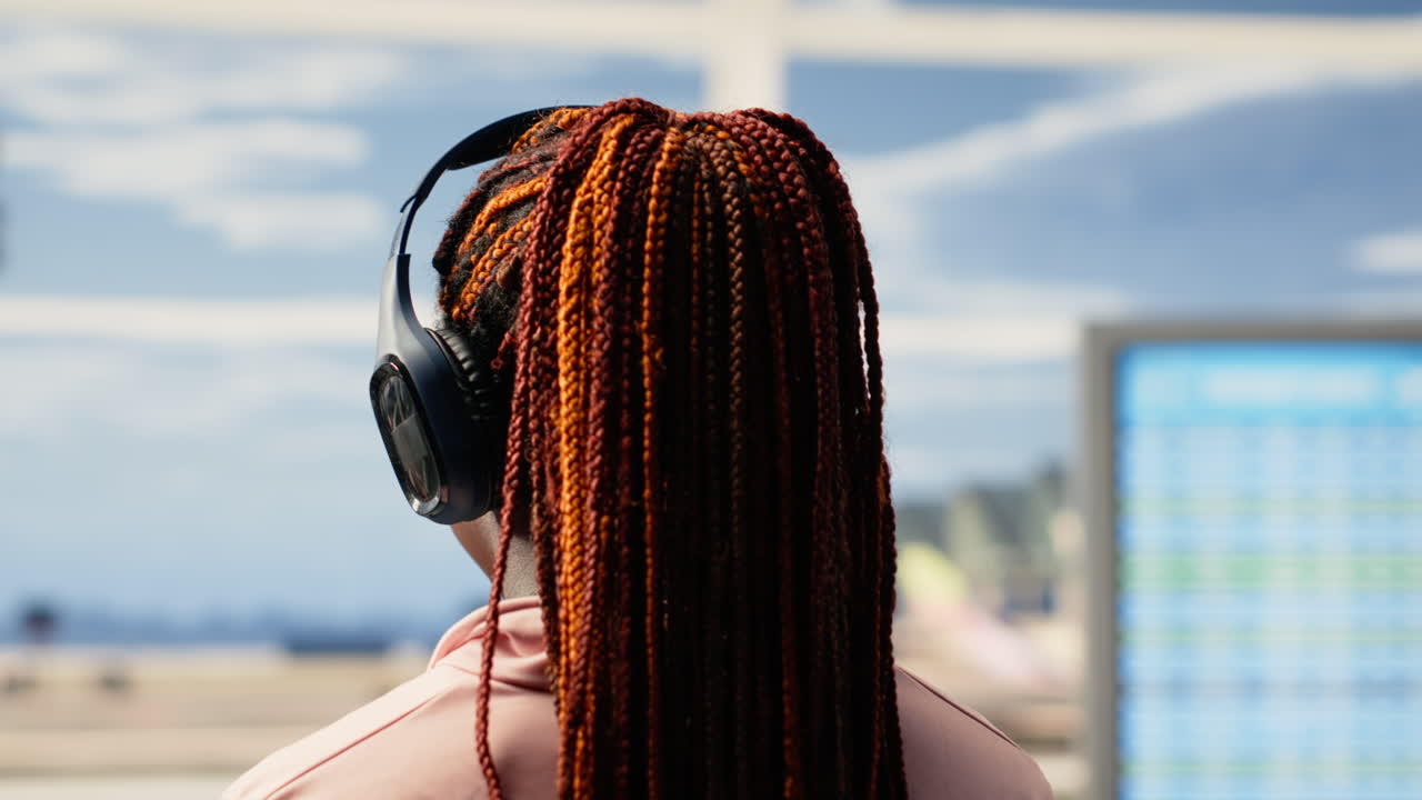 Adolescente ascolta musica, ragazza di colore con le cuffie, in attesa del volo per le vacanze.