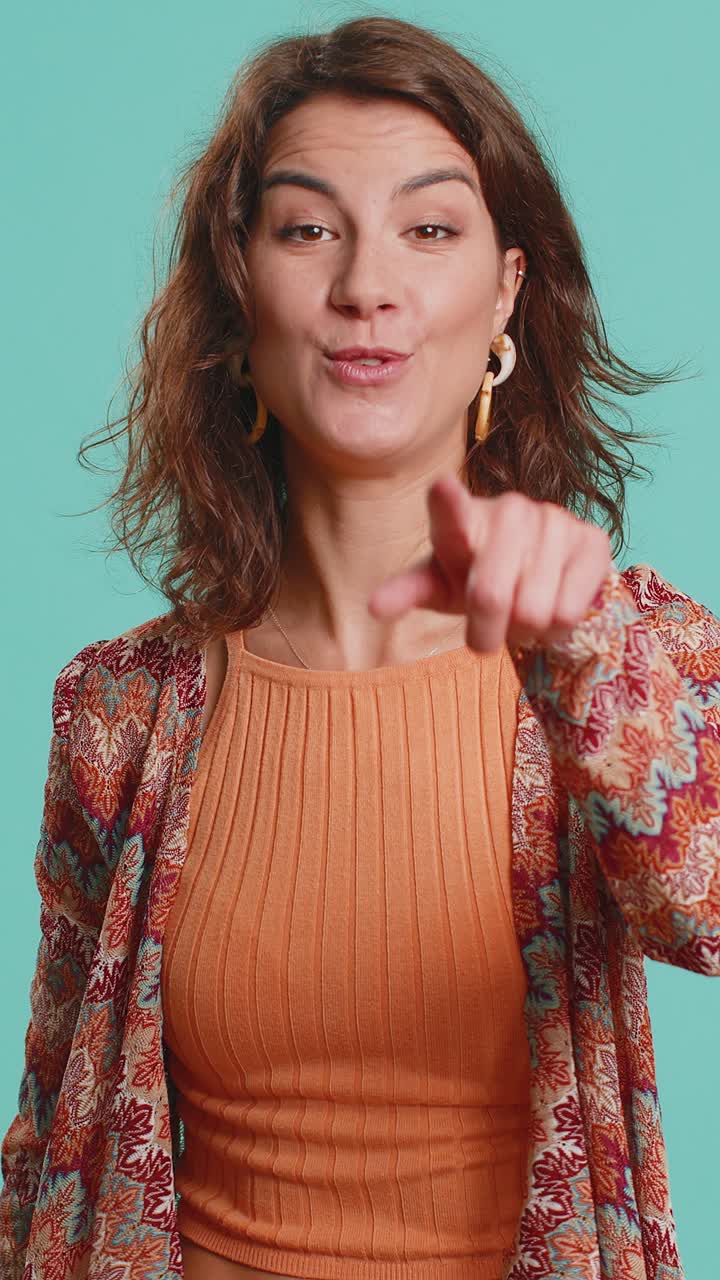 Giovane donna caucasica che indica con il dito la telecamera facendo la scelta vincente mostrando la direzione