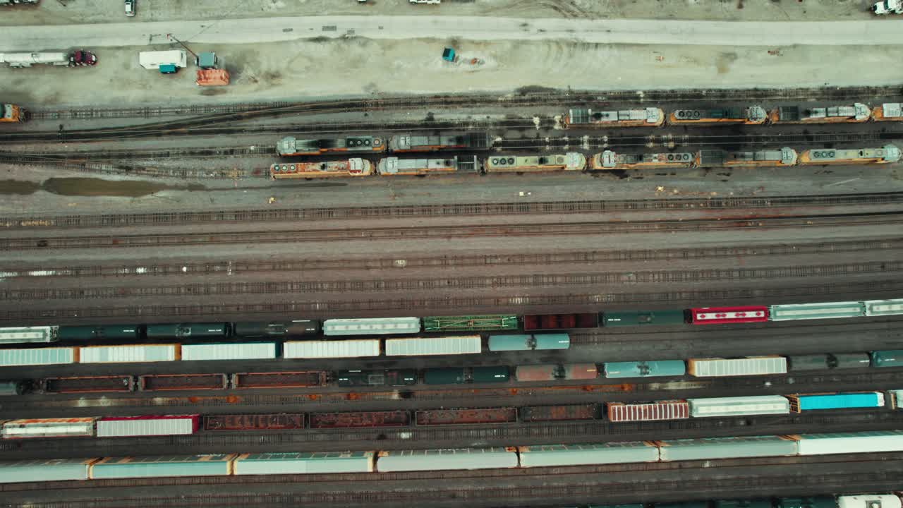 Senkrechte Luftaufnahme von ausgedehnten Eisenbahnsystemen, die Güter- und Pendlerzüge zeigt.