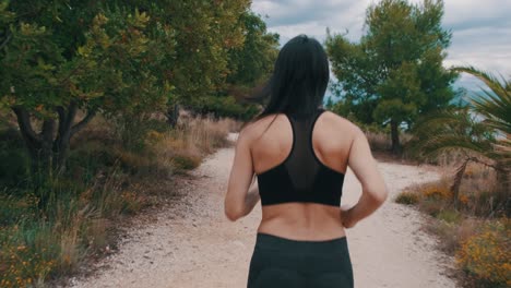 chica trotando junto al mar en un día nublado