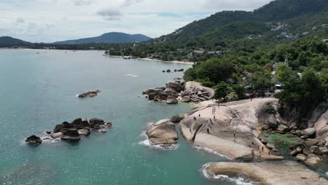 Move-along-shot-of-beach-with-clear-turquoise-water-along-with-green-hilly-mountains