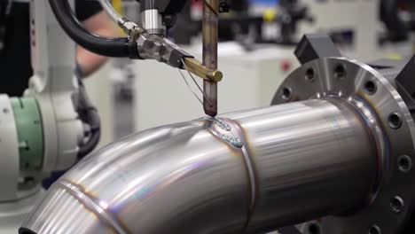 precision welding of metal components in an industrial setting, highlighting advanced robotic machinery and techniques in manufacturing processes