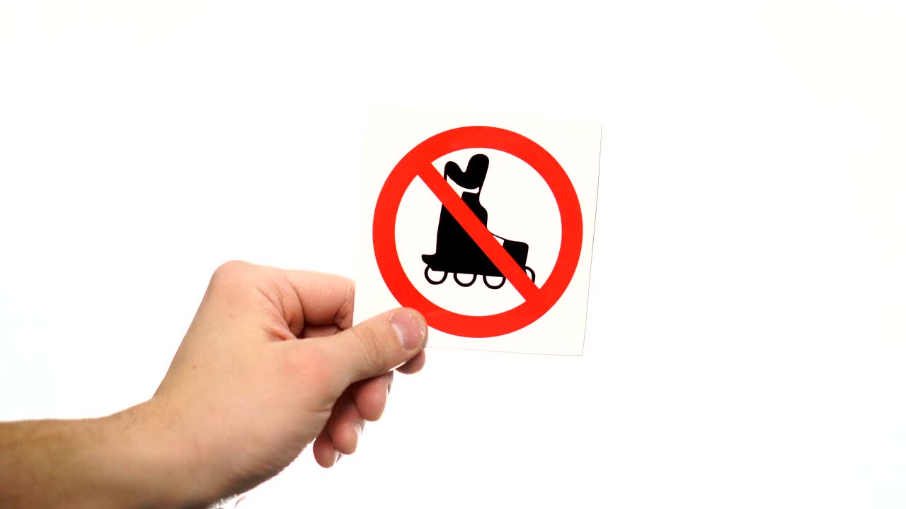 mano que muestra el cartel de advertencia "no patinaje" aislado en blanco