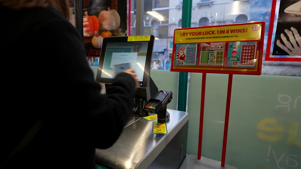 Woman uses phone for contactless payment at supermarket checkout