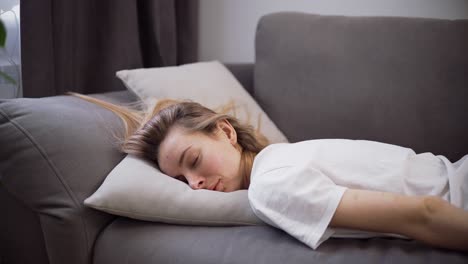 Exhausted-or-bored-young-sleepy-woman-falls-down-on-sofa