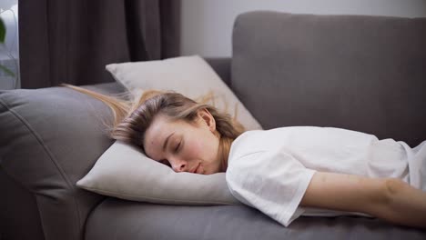 agotada o aburrida joven mujer somnolienta cae en el sofá