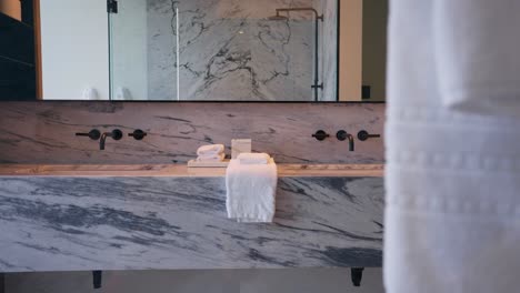 a modern bathroom countertop features twin black faucets on a white and grey granite finished counter