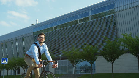 Stylish-man-riding-a-bike-in-a-nice-street-in-the-summer