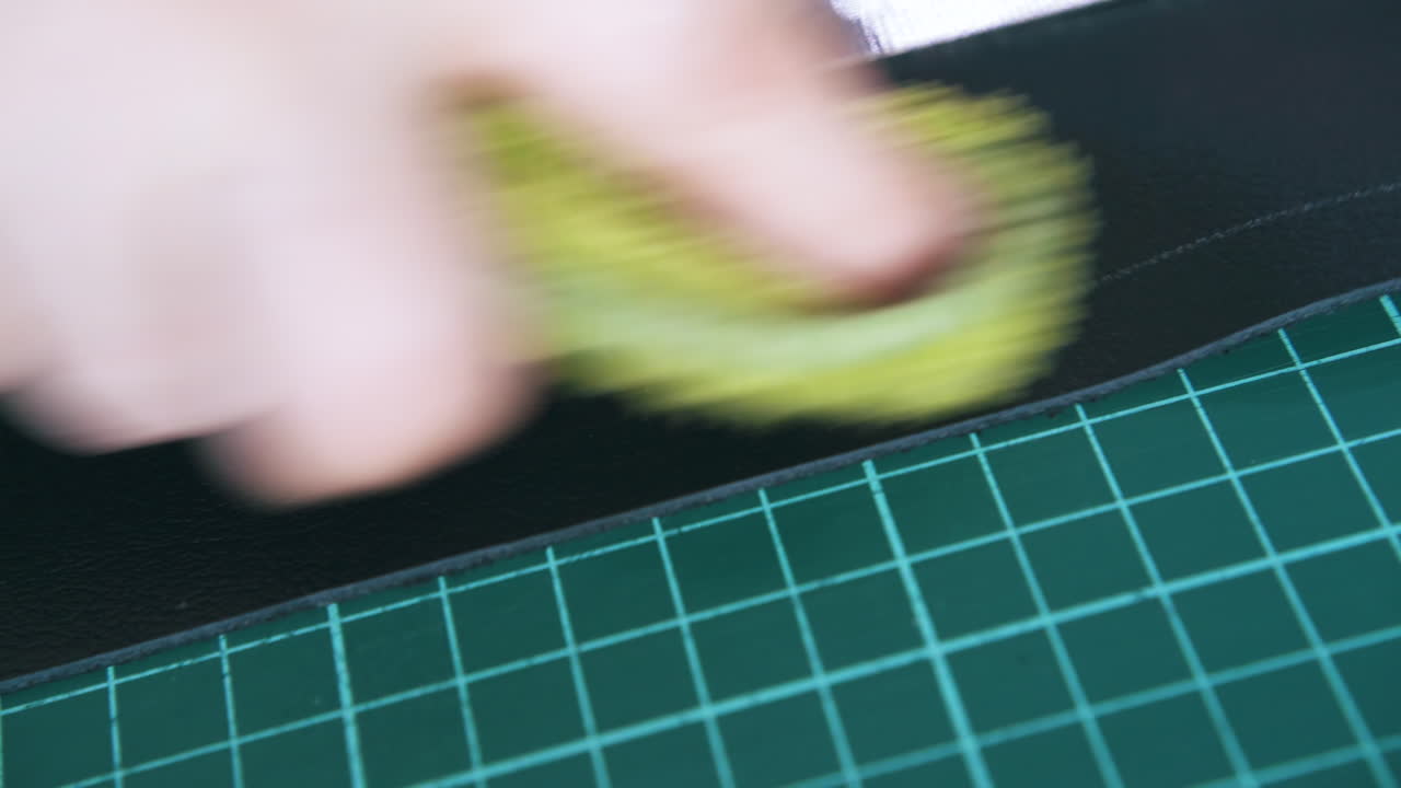 Tailor wipes white line on leather cloth with wet towel