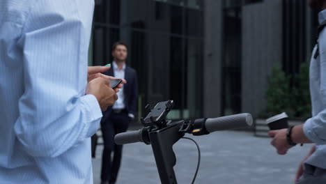 closeup hands rent electric scooter holding smartphone. city transport concept