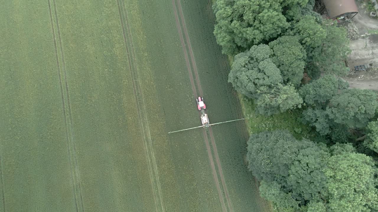 영국 의 한 농장 에서 농작물 을 뿌리는 트랙터 의 4k 항공 영상