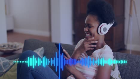 Animation-of-data-processing-over-african-american-woman-using-smartphone-and-headphones