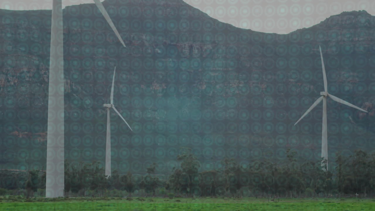 Spinning wind turbines with digital animation overlay in green landscape