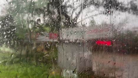 raindrops rolling down window of vehicle while travelling road