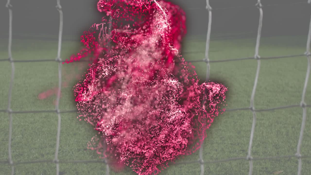 Red particle effect emerging inside net causing goalkeeper diving intercepting soccer ball