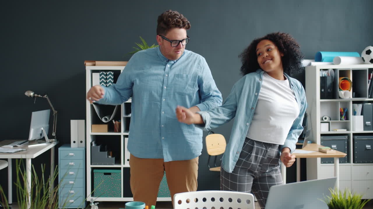 colegas felizes a dançar no escritório.