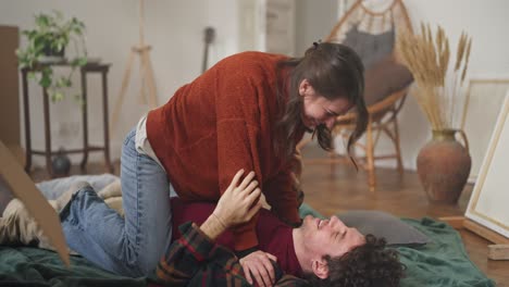 couple kissing and playing in their new home