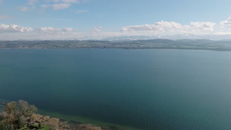 Antena-De-Un-Lago-Con-Colinas-Y-Pueblos-Al-Fondo