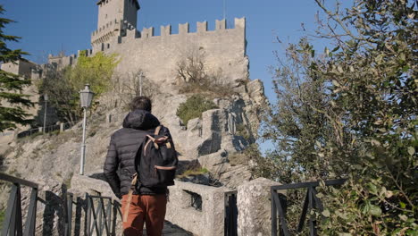 man walking towards a castle on a hilltop