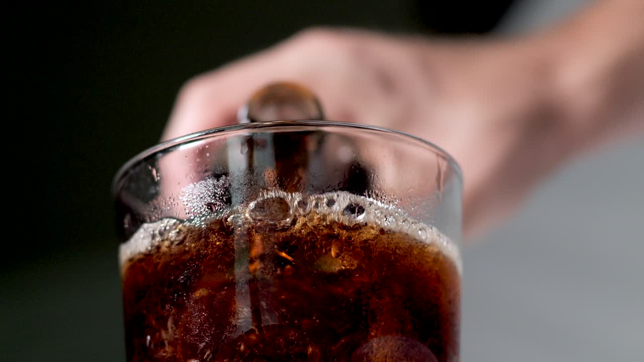 verter coca cola en un vaso de una botella de refresco al aire libre - primer plano - vista de bajo ángulo