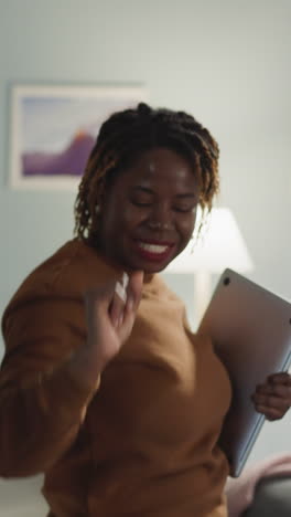 cheerful women enjoy dancing holding laptop and textbook at home. indian and african american students feel happy after finishing task closeup slow motion